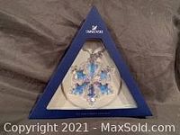 Photo of Swarovski 25th Anniversary Christmas ornament in original blue box with white insert showing the snowflake crystal shaped ornament inside.