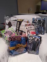Photo of costumes in sealed packaging including black ninja, boxer, morphsuit, skull biker, and horror robe.