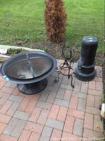 Photo showing all four items: round fire pit with mesh cover, metal plant stand, garden decor and vintage kerosene stove