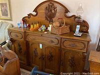 Full front view of oak sideboard showing carved backboard, drawers and doors