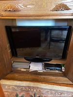 View of Samsung 31-inch TV placed in wooden entertainment center, showing TV screen and base.