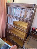 Full front view of four stacked bookcase sections showing overall design and glass doors