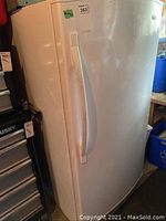 Exterior white upright freezer with curved handle