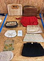 Overview photo showing all 10 bags and purses arranged on plywood surface, highlighting variety in colors and materials.