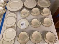 Full set of Lenox Montclair china showing stacked plates, bowls, saucers, and cups on white cloth