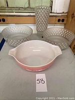 Overview of all items: spotted glass vase, two matching spotted glass bowls, and pink Pyrex mixing bowl with floral design.