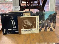 First photo showing six vinyl record album covers including The Trio by Oscar Peterson and Joe Pass, The Wayfaring Stranger, and The Beatles Abbey Road.