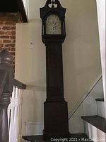 Full height view of dark wood tall case clock showing overall appearance and scale
