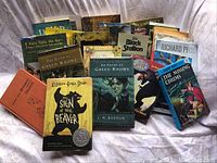 Photo showing over twenty pre-teen books arranged in rows, including 'The Sign of the Beaver', 'The River at Green Knowe', partial view of titles and authors.