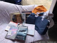 Overview of two bags and about 10 visible books arranged on sofa including Flyboys, War Bride, and Jane Eyre.