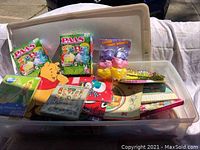 Plastic tote filled with assorted holiday gift bags, Easter egg dye kits, and candy baskets.