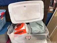 Plastic storage bin with lid containing stuffing and fabric material