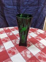 Side view of the green art deco glass vase with rocket shape and vertical faceted sides.