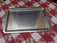 Full top view of the aluminum serving tray showing its rectangular shape and smooth surface with some scratches.
