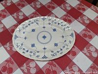 Oval platter photographed on red and white checkered tablecloth with cherry motifs