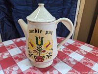 Front view showing 'cookie pot' text and Dutch floral motifs on the ceramic pot shaped like a coffee pot.