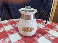 Front side of the coffee percolator showing the fruit pattern and glass lid knob