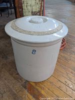 Off-white 8 gallon crock with blue '8' on the side and 10 gallon lid on top, showing the exterior condition and fit.