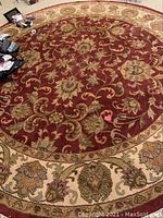 Top-down photo showing the full pattern and colors of the round floral area rug.
