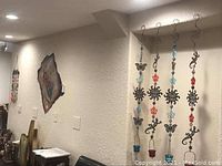 Wall art including four matching hanging pieces and the largest metal wall piece tacked on wall