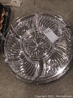 Top view of a clear crystal lazy Susan with curved compartments, showing the design and cut pattern.