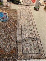 Wide shot showing both carpets side by side on the floor, illustrating their size difference and pattern details.