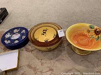 Photo showing the arrangement of the large sunflower bowl, 3 nesting olive motif bowls, and blue round tray