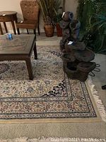 Full view of the light colored rug with floral pattern and fringed edges under furniture.