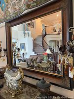 Mirror reflecting a studio living room with staircase, showing the front view and size placement of the mirror