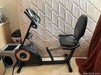 Side view of Pro-Form recumbent exercise bike showing seat, pedals, frame and part of console.
