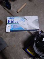 Box of Astor CB-1000 bidet, showing product branding and packaging details.