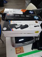 Photo showing Epson Perfection 3170 Photo scanner closed on table with HP toner cartridge boxes stacked on top