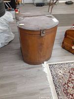 Full view of the wooden flour bin standing on a wood-look floor, showing its shape and general condition.