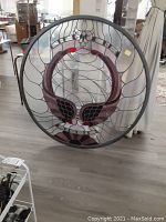Front view of round stained glass panel leaning upright