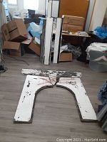 Overall view of fireplace surround pieces laid flat on floor showing arched opening and separate side jamb pieces.