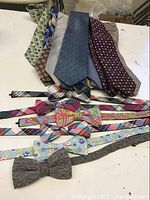 Overview of 12 worn neckties in various colors and patterns along with 6 adjustable bow ties in assorted patterns