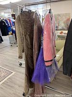 Rack view of three dresses and one jacket hanging