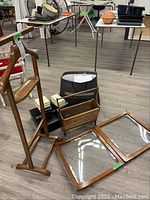 Valet stand, cabinet doors laid flat, magazine rack, and brand name boxes grouped on floor