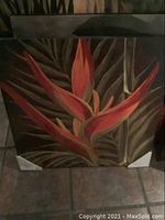 Canvas painting showing Bird of Paradise flower with leaves, corner protectors visible, floor background.