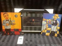 Photo showing three pieces: central black framed 'Room Service' artwork flanked by two colorful waiter plaques with cartoon waiters.