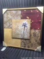 Framed square art piece with cream, maroon, gold and floral textured panels and corner protectors in place