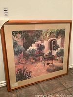 Framed art print in natural wood frame with scene of garden courtyard