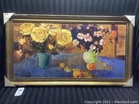 Full view of framed painting featuring two vases with yellow and pink roses on a blue tablecloth with fruit.