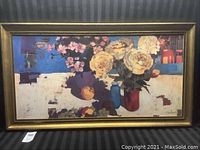 Full view of framed floral art print on a black striped background.
