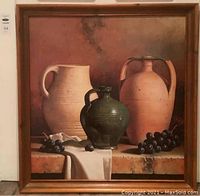 Full view of the framed still life painting showing three jugs and grapes on a ledge with neutral background.