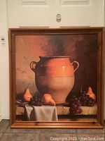 Full view of framed painting featuring a large terra cotta confit jar with pears and grapes arranged on a table with cloth.