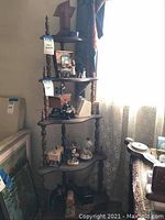 Shelf filled with assorted small decorative pieces including figurines, boxes, glass dome display and framed mirror