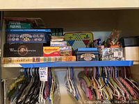 Shelf with multiple boxed games including Skip-Bo, Chinese Jacks, Dominos, The Game of Life, Kodak film box and others
