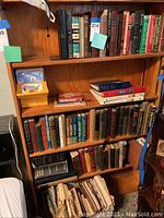 Wooden bookshelf with multiple shelves filled with hardcover books