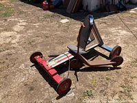 Photo of the vintage wooden racer and metal scooter placed on dirt ground showing side and top views.